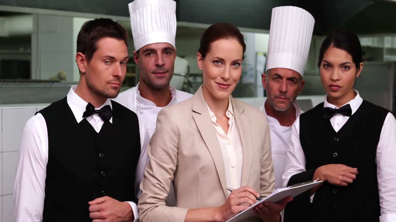 personal serio del restaurante con el gerente mirando a la cámara