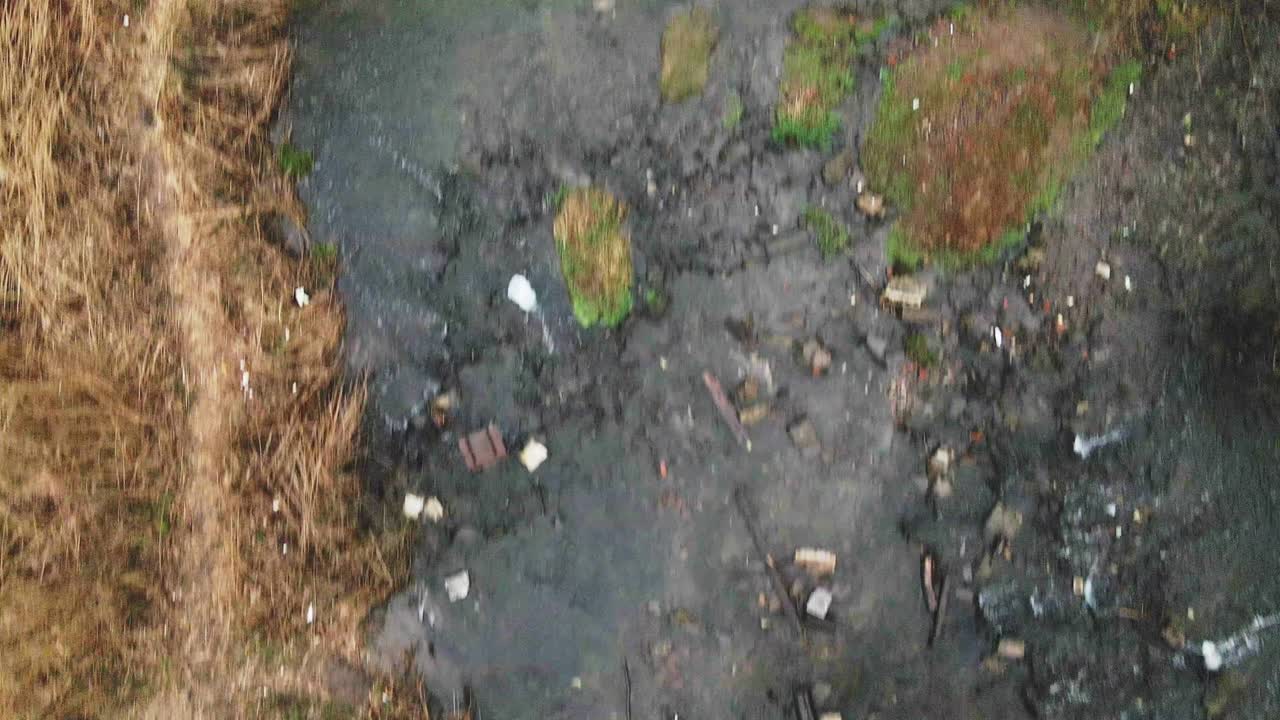 летает над бетонными канализациями. потоки воды протекают через бетонные трубы. загрязненный водоем в парке.