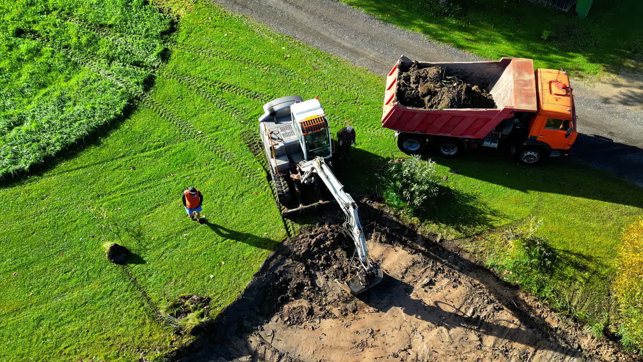 Excavator and Dump Truck Moving Soil at Construction Site