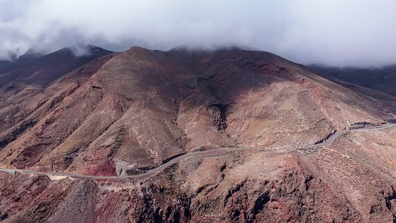 Drone slowly pulls back revealing isolated mountain road in Canary Islands