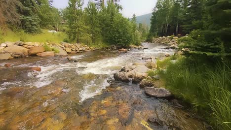 Gebirgsbach-Mit-Frischem-Wasser,-Das-Mit-Felsen-Und-Grün-Fließt