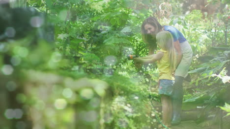 video of blue lights over caucasian woman and daughter working in garden