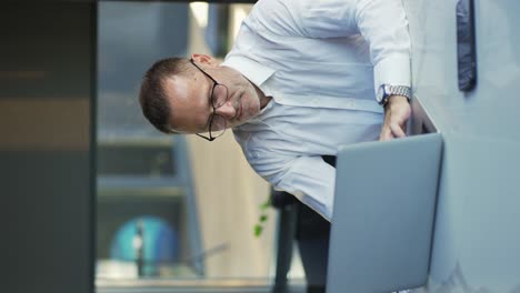 hombre de negocios sonriente trabajando en una computadora portátil en la oficina de casa. hombre profesional escribiendo en el teclado de la computadora portátil en el lugar de trabajo de la oficina