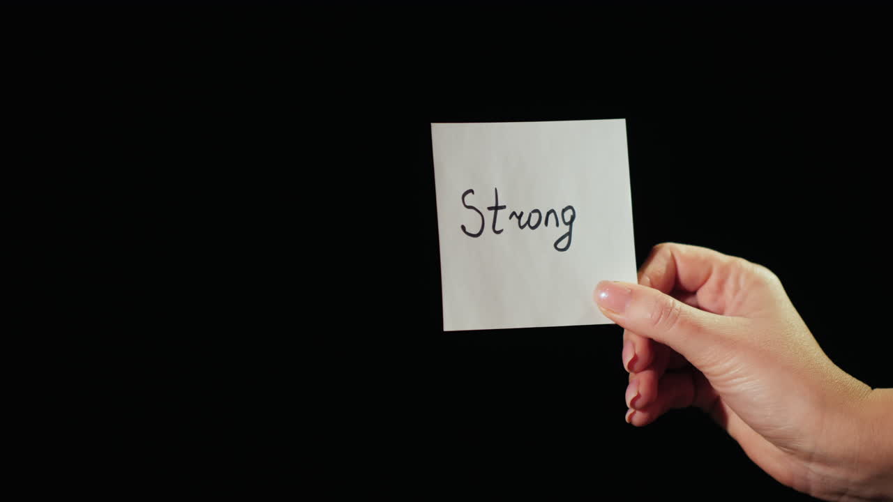 Man Burns A Paper With The Inscription Strong