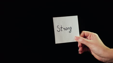 man burns a paper with the inscription strong