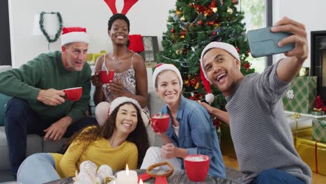 happy group of diverse friends using smartphone and taking selfie