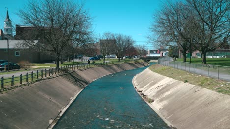 creek running through a town via a concrete duct