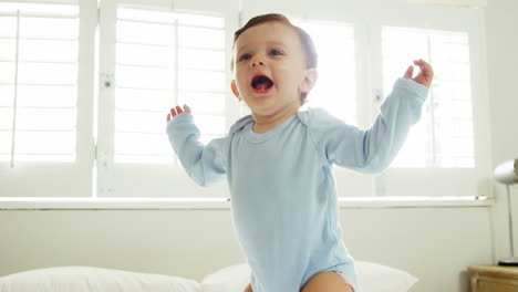 a baby boy is jumping in a bed