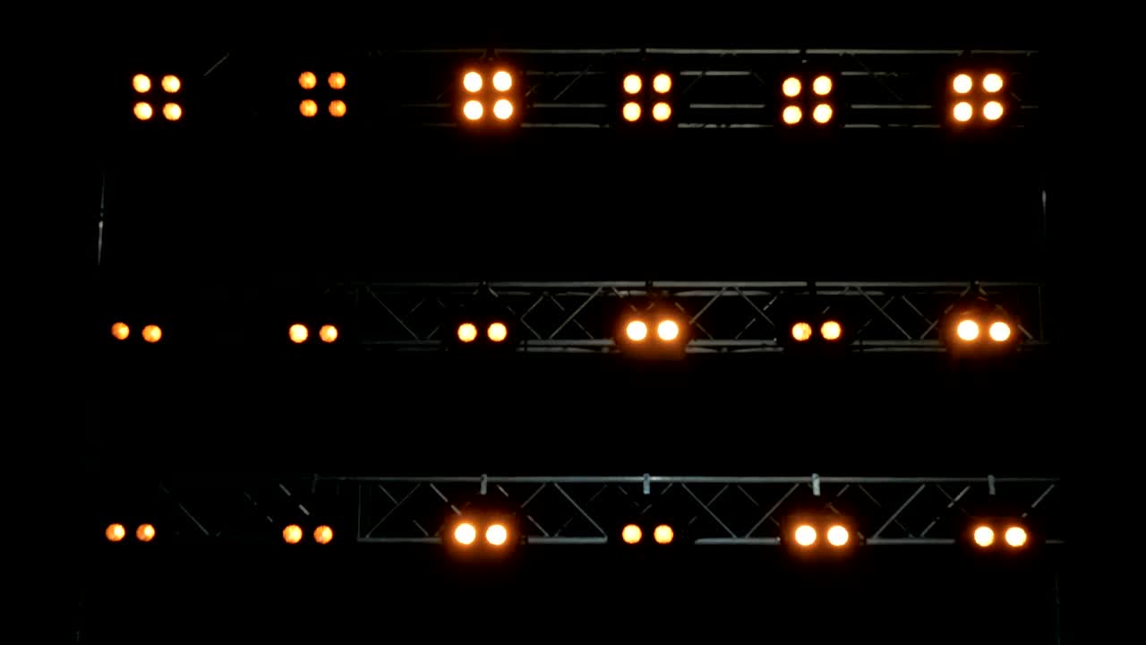 Blurred background of yellow lghts. Lights on the black stage.