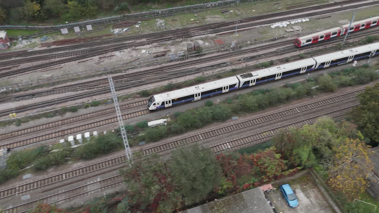 Aerial view capturing Elizabeth line and Underground trains converging at railway junction near Ealing Central Station, showcasing modern transit infrastructure in London, UK, October 2024