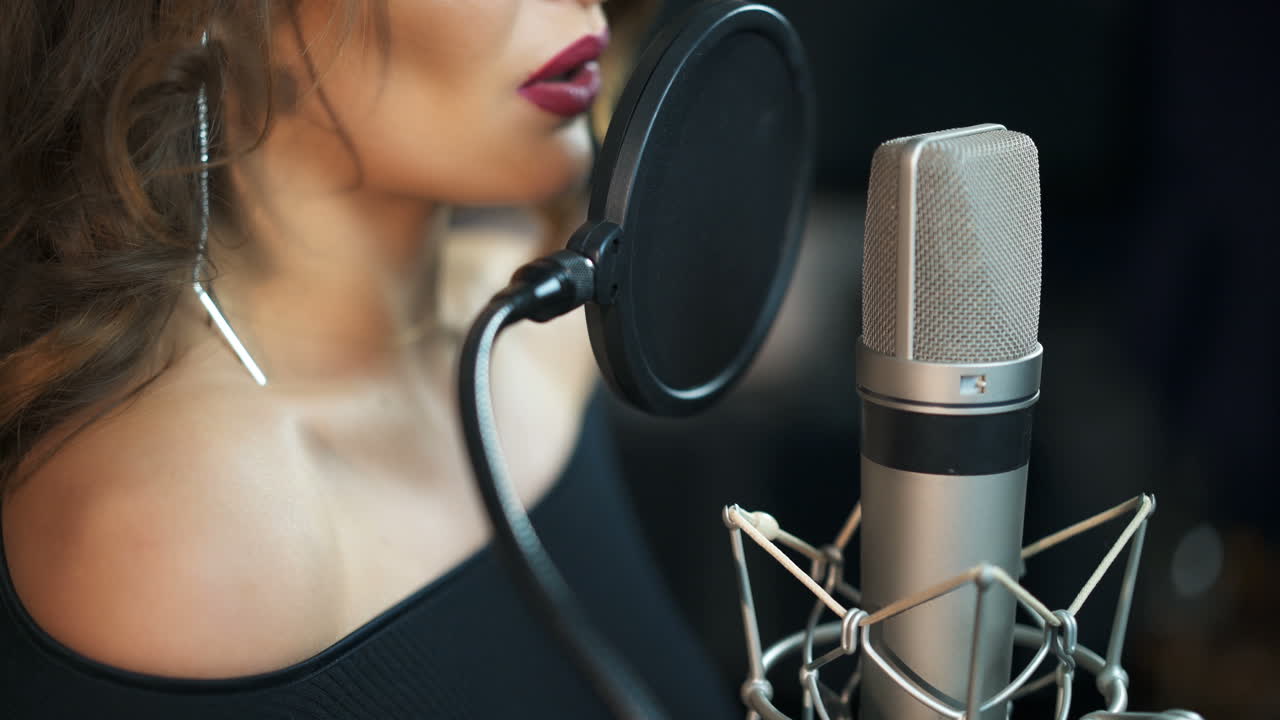 Beautiful sexy young woman singing. Female vocal. Professional recording studio.