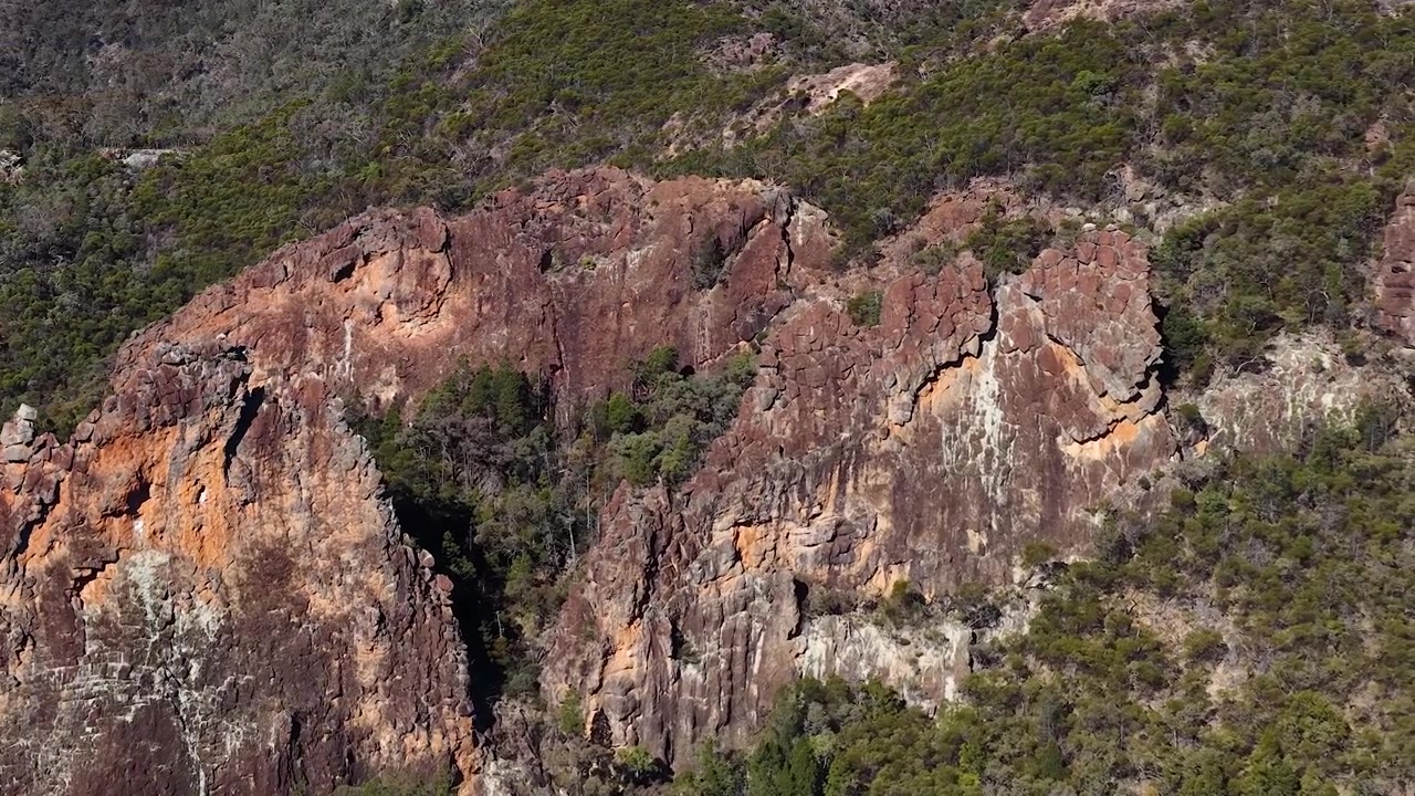 Ampia inquadratura di una formazione rocciosa a collo vulcanico sotto la luce del giorno intensa nel Parco Nazionale Warrumbungle