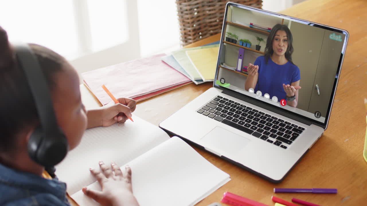 composición de una colegiala afroamericana en una computadora portátil aprendiendo en línea con un maestro biracial