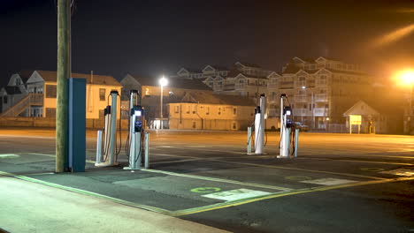 Electric-car-charging-station-at-night-in-an-empty-parking-lot