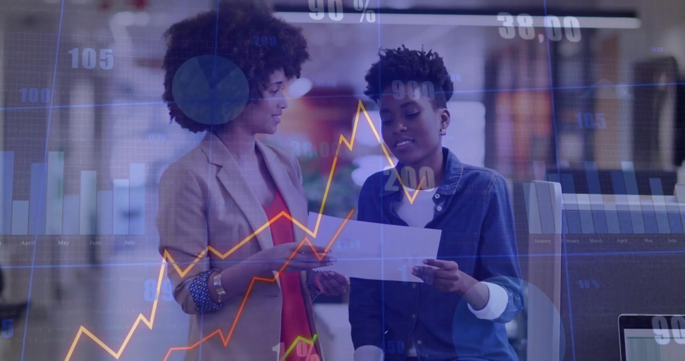 Left woman tilting printed report toward right woman causing animated graphs showing finance trends