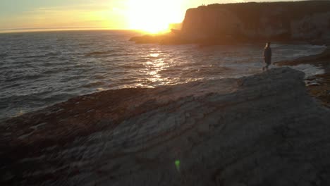 a cinematic video clip of cliffs by the ocean during sunset