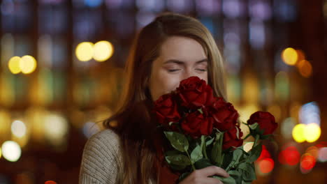 romantic girl smelling flowers outdoors. affectionate woman holding bouquet.