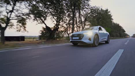 Presentation of a white Audi e-tron, compact luxury crossover SUV. Modern new cars for sale