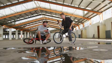 bmx riders talking in an empty warehouse