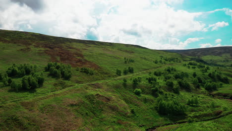 Aerial-rising-shot-of-the-green-hills-and-mountains-of-the-English-Lake-District,-bright-sunny-day