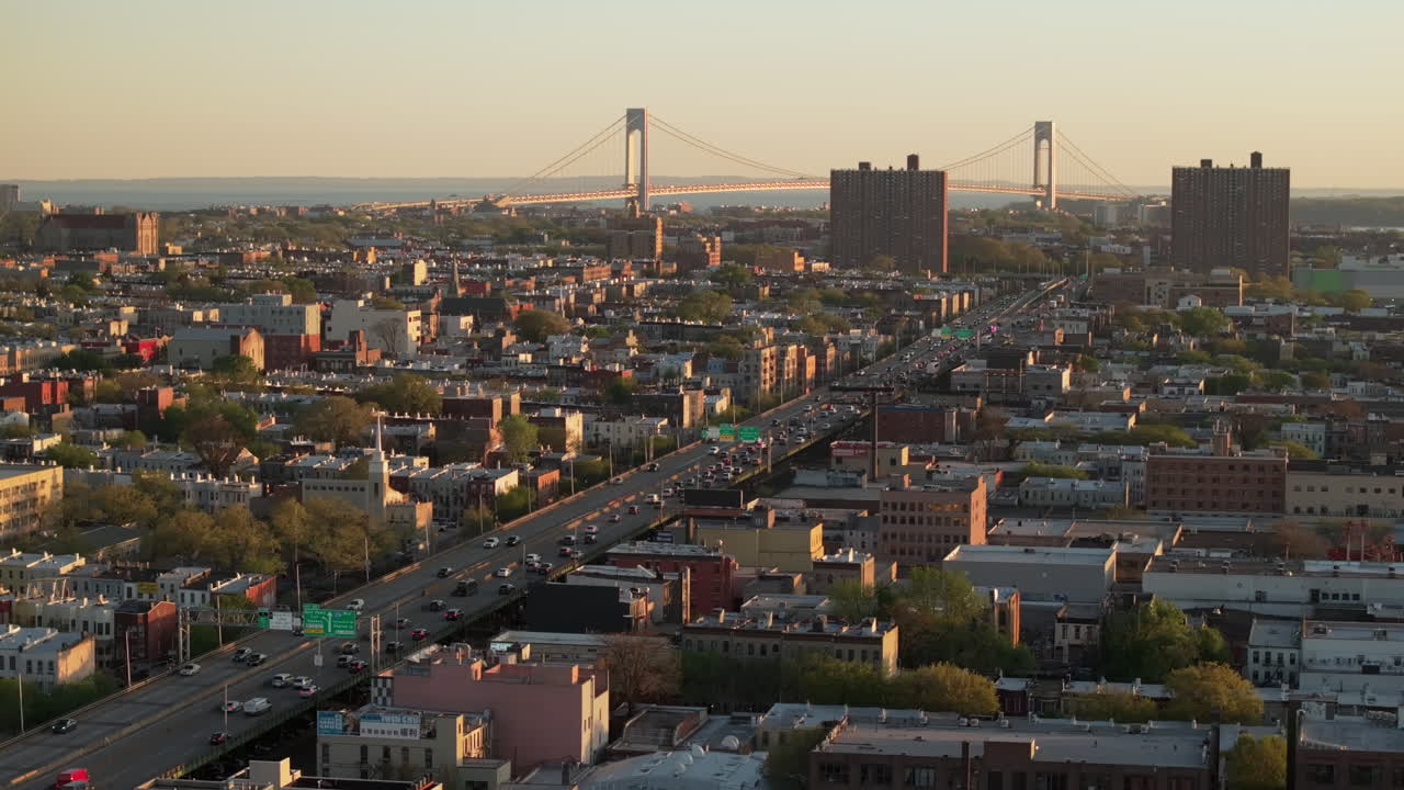 Aerial view of rush hour traffic on Brooklyn's Belt Parkway. Shot at sunset in Bay Ridge with the Verrazzano Bridge in the background.
