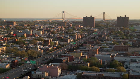 aerial view of rush hour traffic on brooklyn's belt parkway. shot at sunset in bay ridge with the verrazzano bridge in the background.
