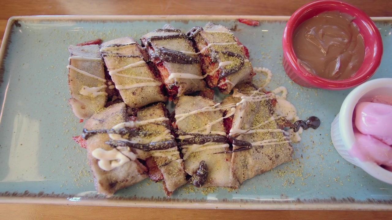 Skiver af crepe-dessert med chokoladesauce og is