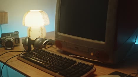 slow zoom toward vintage tech on desk, old camera and desktop pc