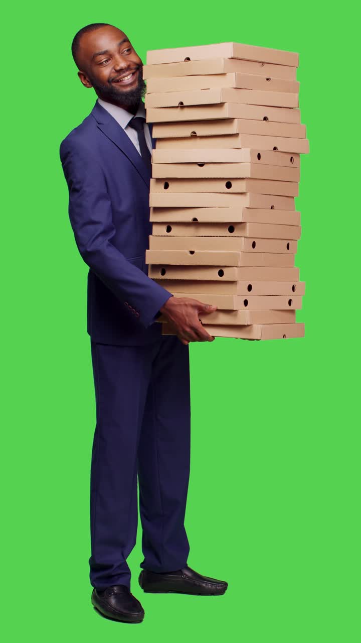 Video vertikal: Tampilan samping pengusaha pria memegang tumpukan besar kotak pizza