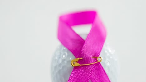 animación de cinta rosa, alfiler de seguridad y pelota de golf sobre fondo blanco