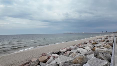 sandy beach with a stone breakwater in stormy weatcher