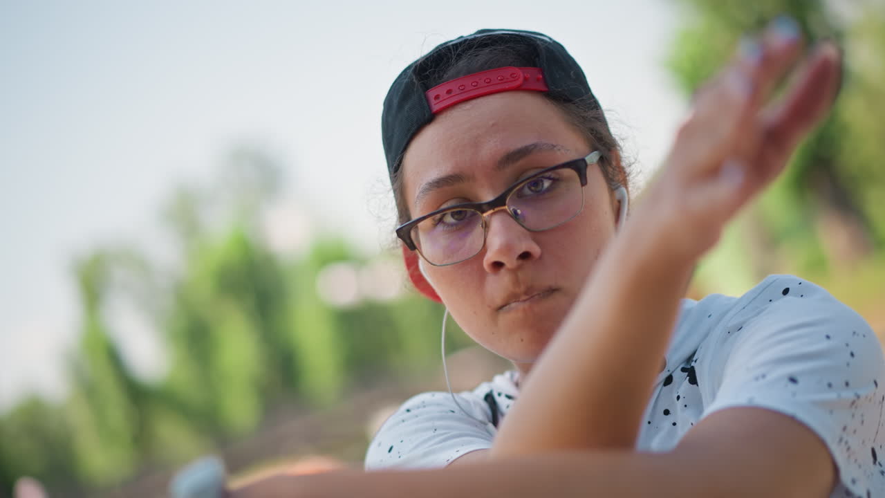 Teen performing in park setting, Teenager engaged in playful dance near water feature outdoors, Young adult having fun practicing dance moves with expressive gestures outdoors near pond