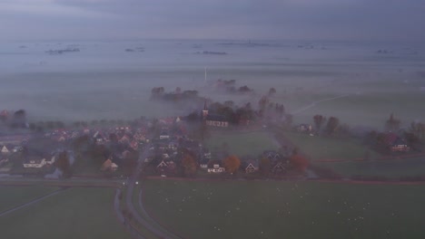 Burgum-in-Friesland,-Dutch-countryside-covered-in-morning-mist,-aerial