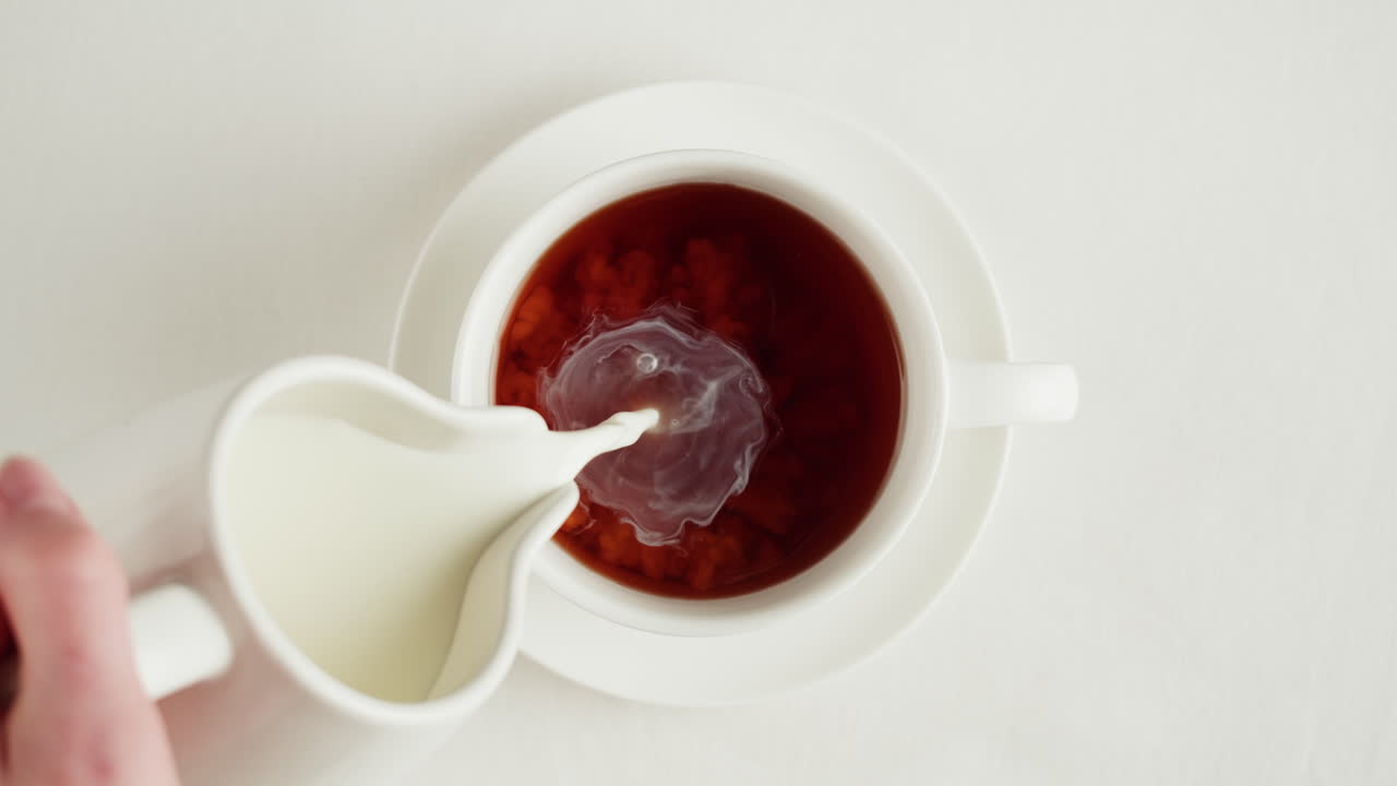 Pouring milk into a cup of coffee