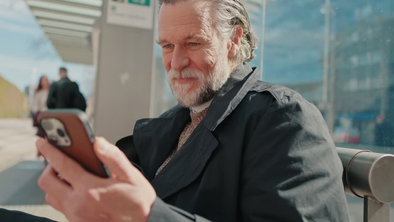 Smiling Man Using Phone at City Bus Stop