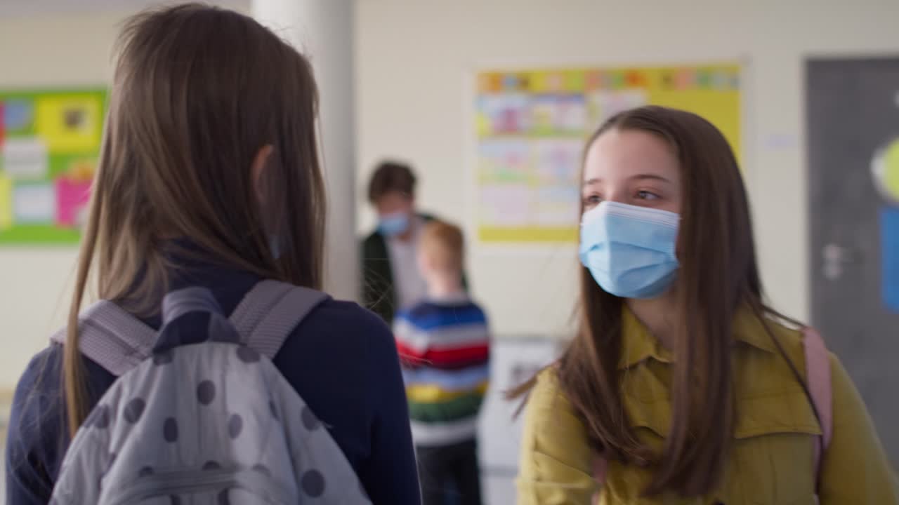 보호 마스크를 입은 소녀들이 팔꿈치 인사를 하는 동영상