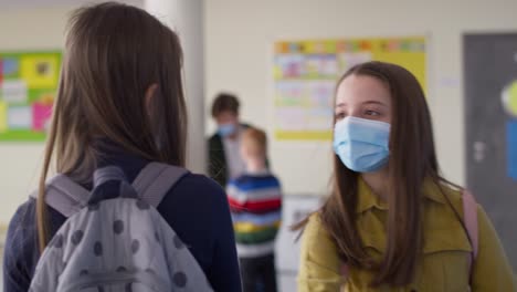 video de chicas con máscaras protectoras saludando con el codo