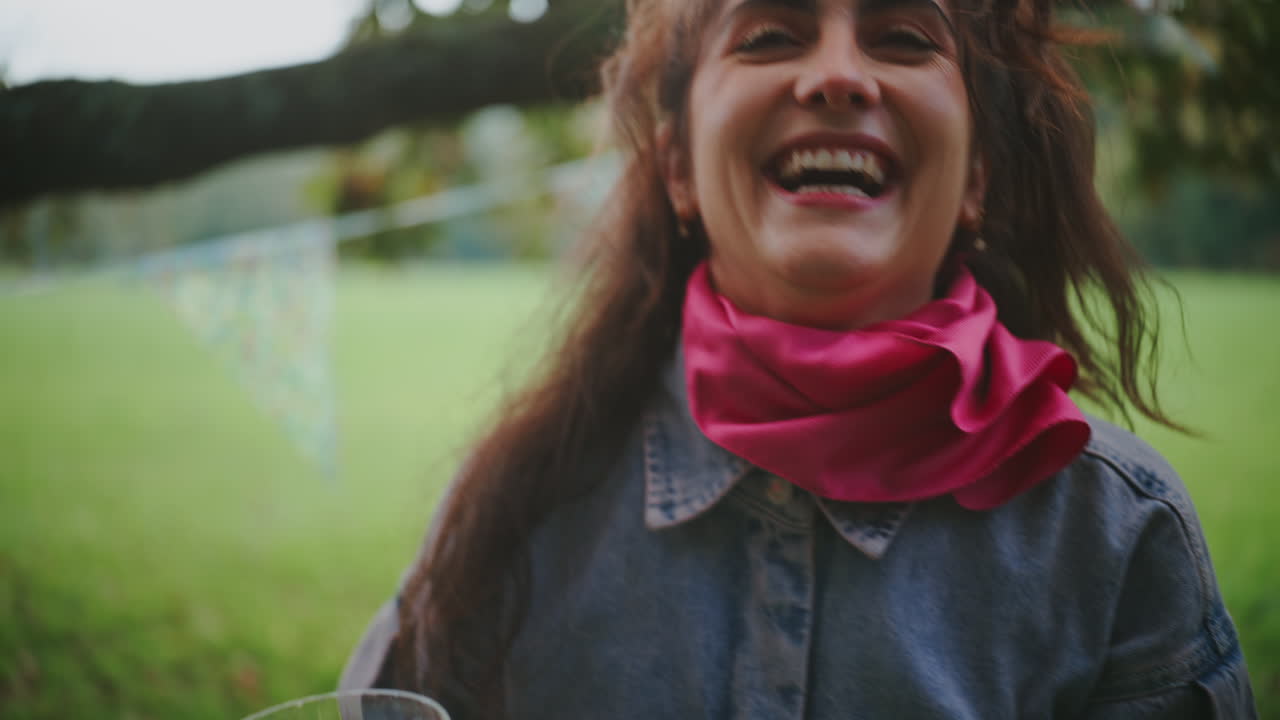 una mujer feliz riendo en un parque.
