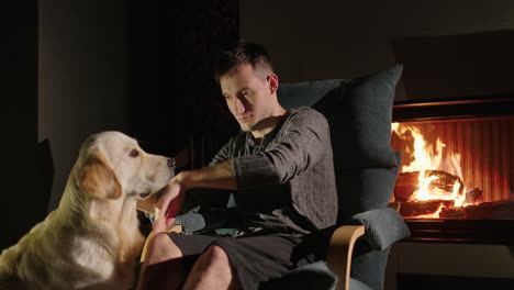 man and dog by fireplace at night