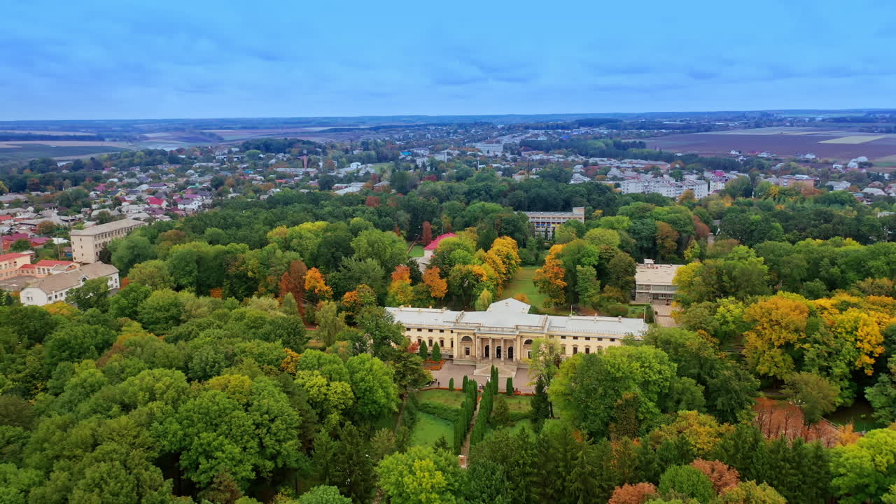 Rising over the green park with amazing palace locating in the middle. Cityscape and farmlands at backdrop.