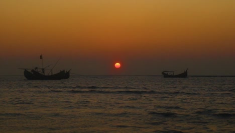 sunset with wooden fishing boats at the coastline of saint martin island, teknaf, bangladesh