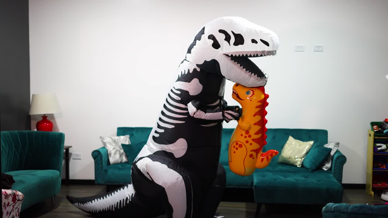 disfraz de dinosaurio de halloween con hombre en la sala de la casa