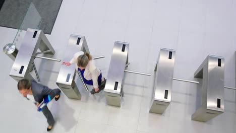 Businesswomen-scanning-their-cards-at-turnstile-gate