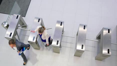 mujeres de negocios escaneando sus tarjetas en la puerta del torniquete