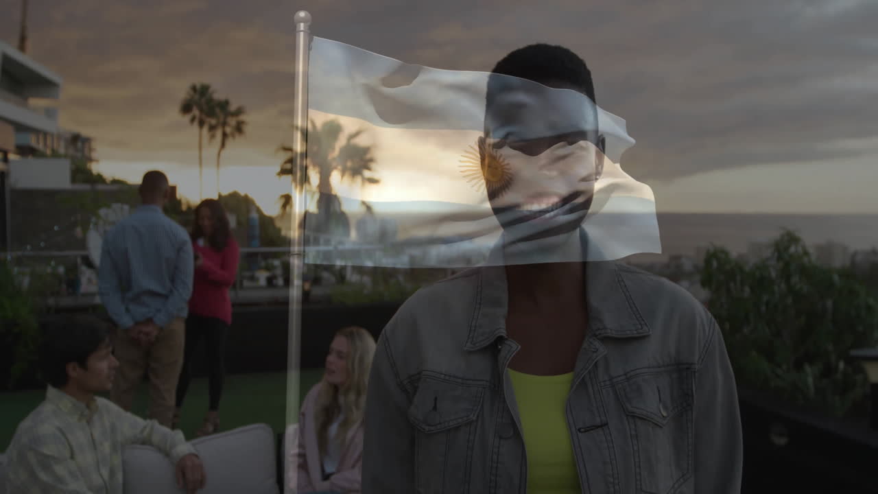 Holding Argentina flag, person smiling at outdoor gathering near sunset animation