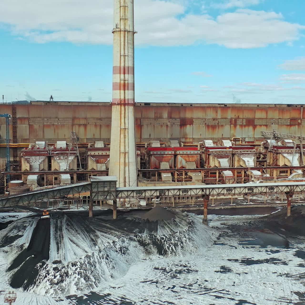 Heat power station with two high pipes is on the river bank on the outskirts of the city. Aerial view.