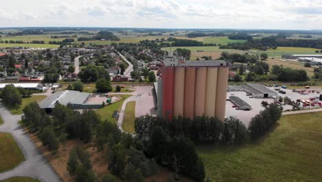 Aerial-landscape-shot-of-Swedish-company-Lantmännen-Lantbruk-in-agriculture-industry,-the-grains-storage-silos,-manufacturing-factory-site-in-rural-countryside-in-Brålanda-Vänersborg-Sweden