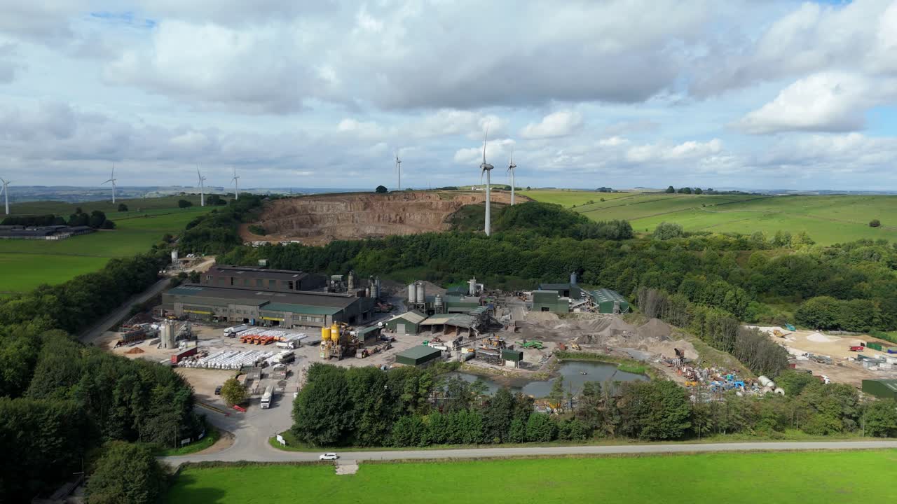 Aerial perspective of wind turbines, industrial aggregates, and rural landscapes in Derbyshire Dales United Kingdom