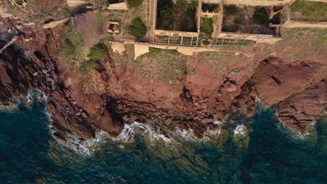 Top-down-aerial-view-of-rugged-coastline-in-South-Sardinia-in-Nebida,-sideways