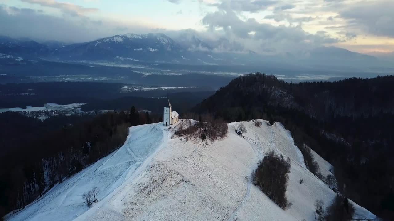 vista de la iglesia jamnik en un paisaje invernal con un colorido amanecer en kranj, eslovenia